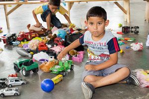 1414 a crianca e o consumo menino com muitos brinquedos