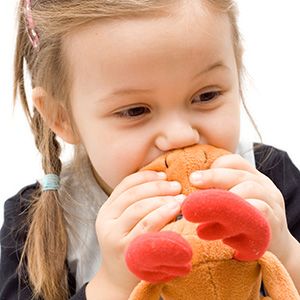 criança com brinquedo na boca